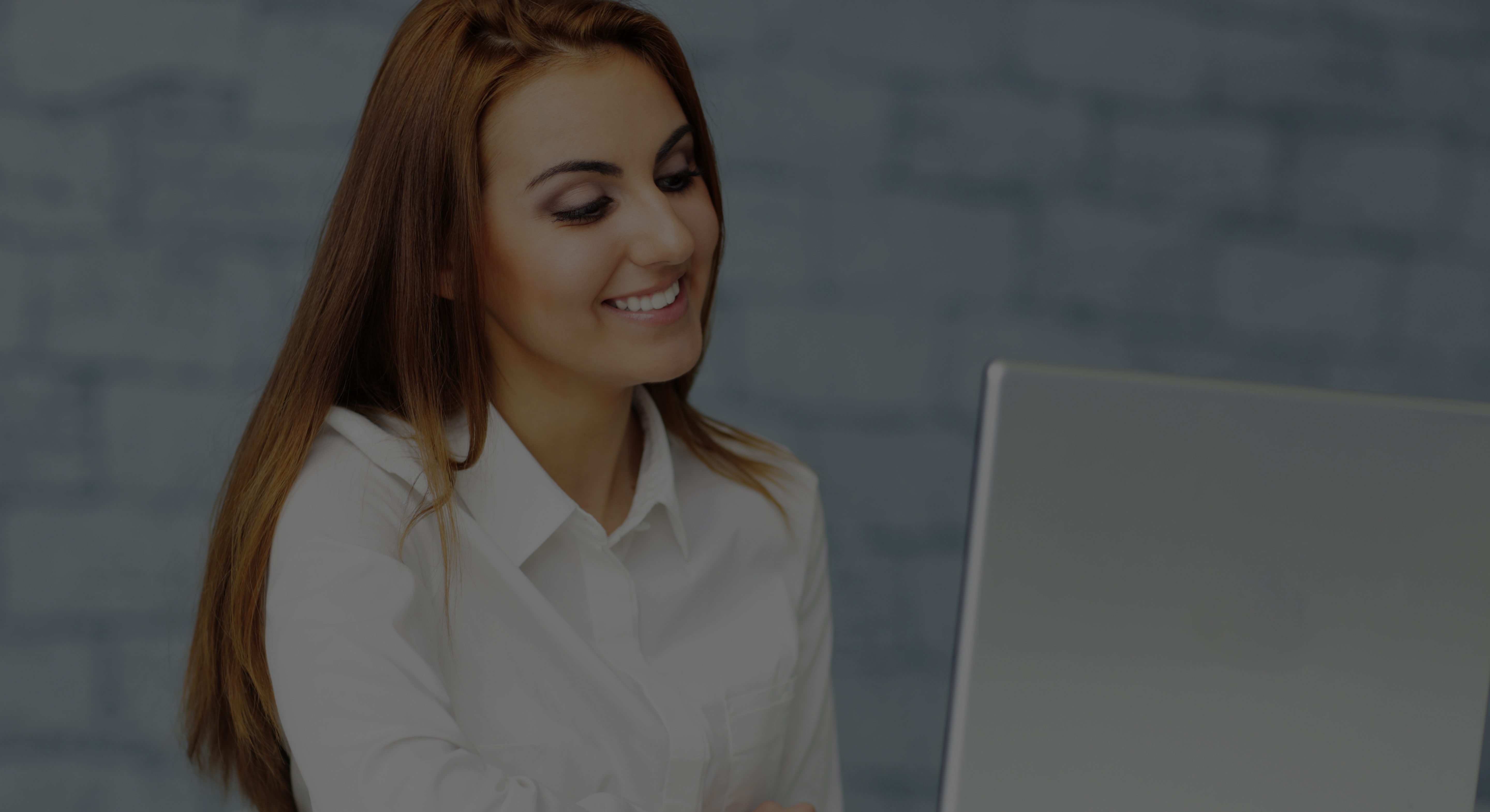 Confident happy businesswoman working on laptop in office